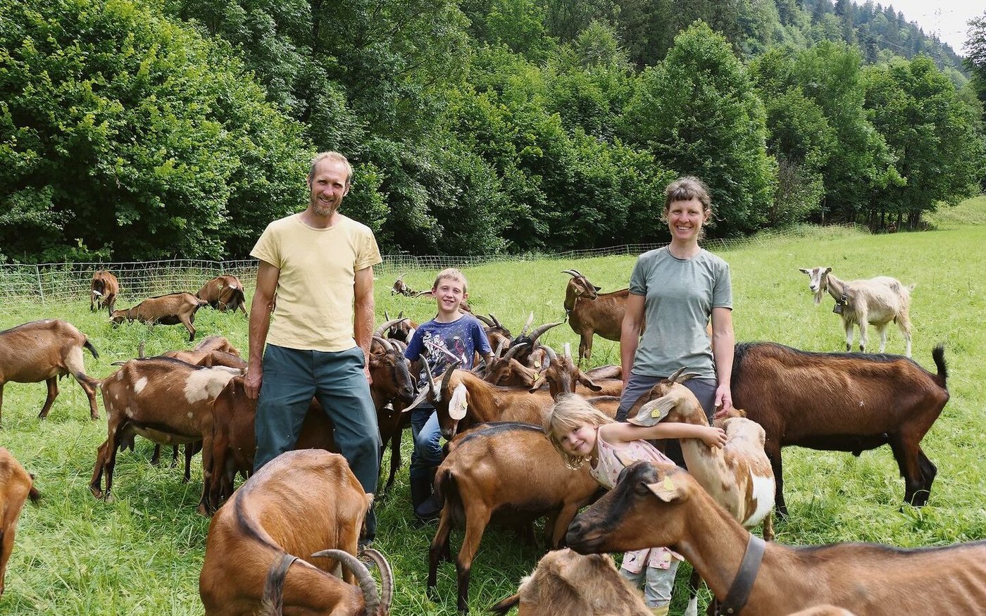 Samuel Bommeli und Simone Burki mit den Kindern Orell und Lina inmitten ihrer anhänglichen Ziegen auf einer der wenigen eher flachen Weiden. Die meisten Parzellen des Betriebs befinden sich dagegen in Steillage.