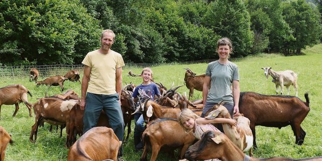 Samuel Bommeli und Simone Burki mit den Kindern Orell und Lina inmitten ihrer anhänglichen Ziegen auf einer der wenigen eher flachen Weiden. Die meisten Parzellen des Betriebs befinden sich dagegen in Steillage.