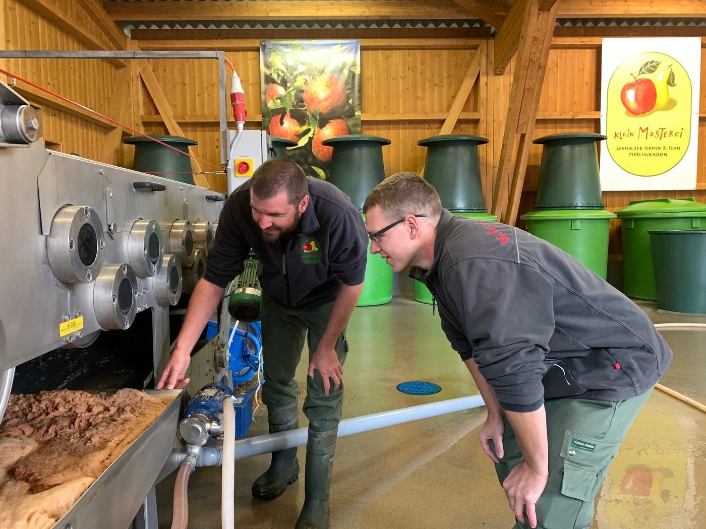 Pirmin Seeholzer (l.) und Christian Arnitz von der Kleinmosterei in Udligenswil begutachten den Saft aus der Bandpresse (Bild js)