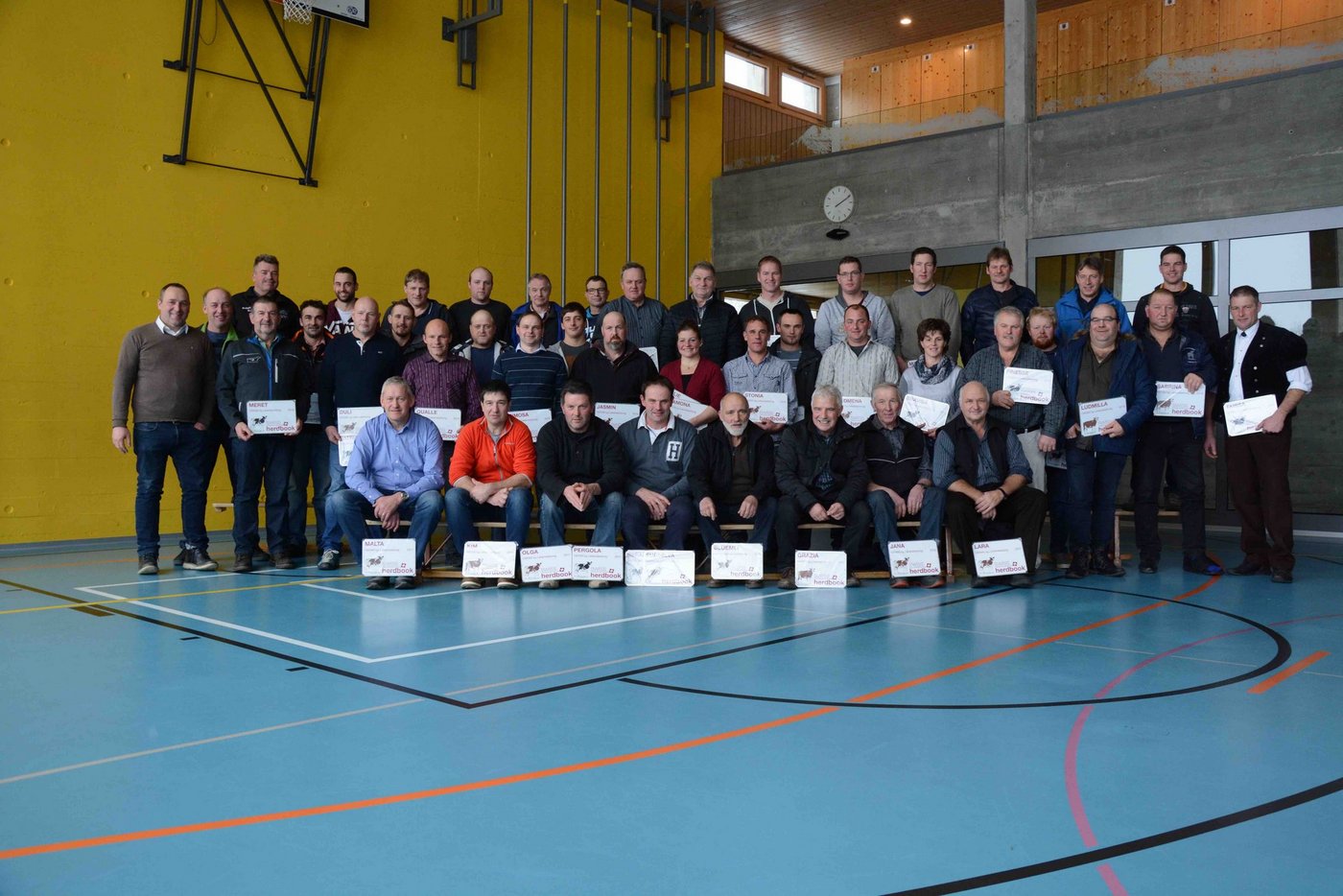 Die stolzen Besitzer der 100000er Kühe erhielten von Swissherdbook-Präsident Markus Gerber (links) Plaketten. (Bild sb)