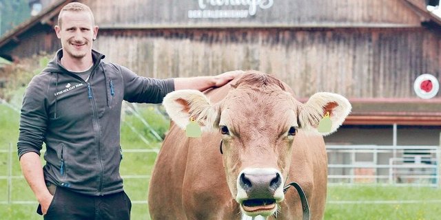 Wie seine Original Braunviehkuh Lisa strahlt auch Thomas Bricker, der Betriebsleiter vom Erlebnishof Fronalp, trotz dem aktuellen Heuwetter und den vielen Gästen grosse Gelassenheit aus.