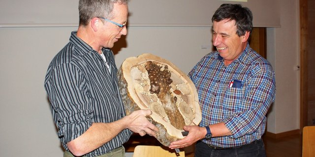 Präsident Peter Stadelmann überreicht Toni Moser ein Wildbienenhotel für 30 Jahren Tätigkeit als Berater und Aktuar für die "Entlebucher Kräuter". (Bild Sandra Steffen)