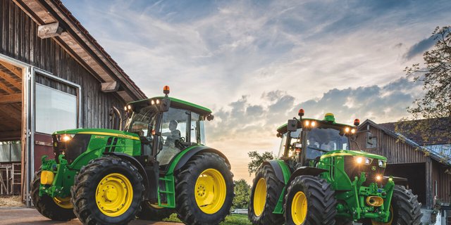 Zwei John Deere-Traktoren im Gegenlicht.