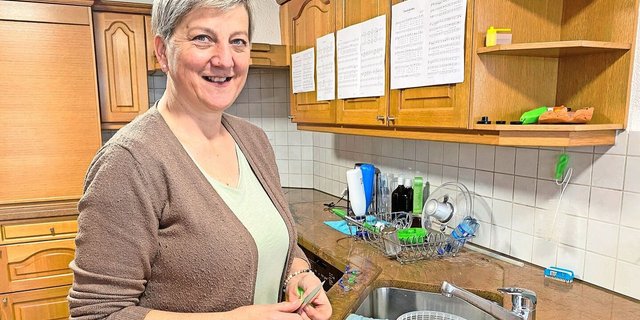 Sandra Bucher hat die Jodellieder an die Küchenschränke geheftet und übt während des Rüstens. 