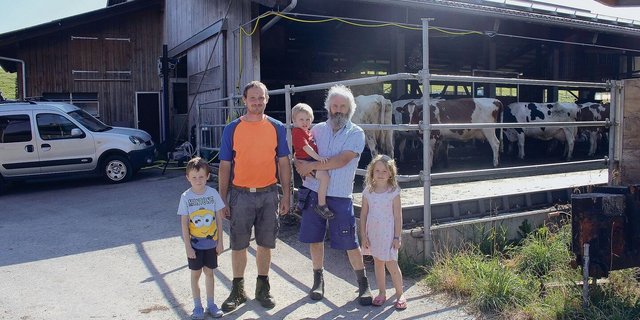 Drei Generationen auf einen Blick: Leon, Hofnachfolger René Joss, Vater Heiri mit den Enkeln Silvan und Nora (v. l. n. r.). Sie stehen vor dem Milchviehstall der Betriebsgemeinschaft Allenwinden-Berghof. 