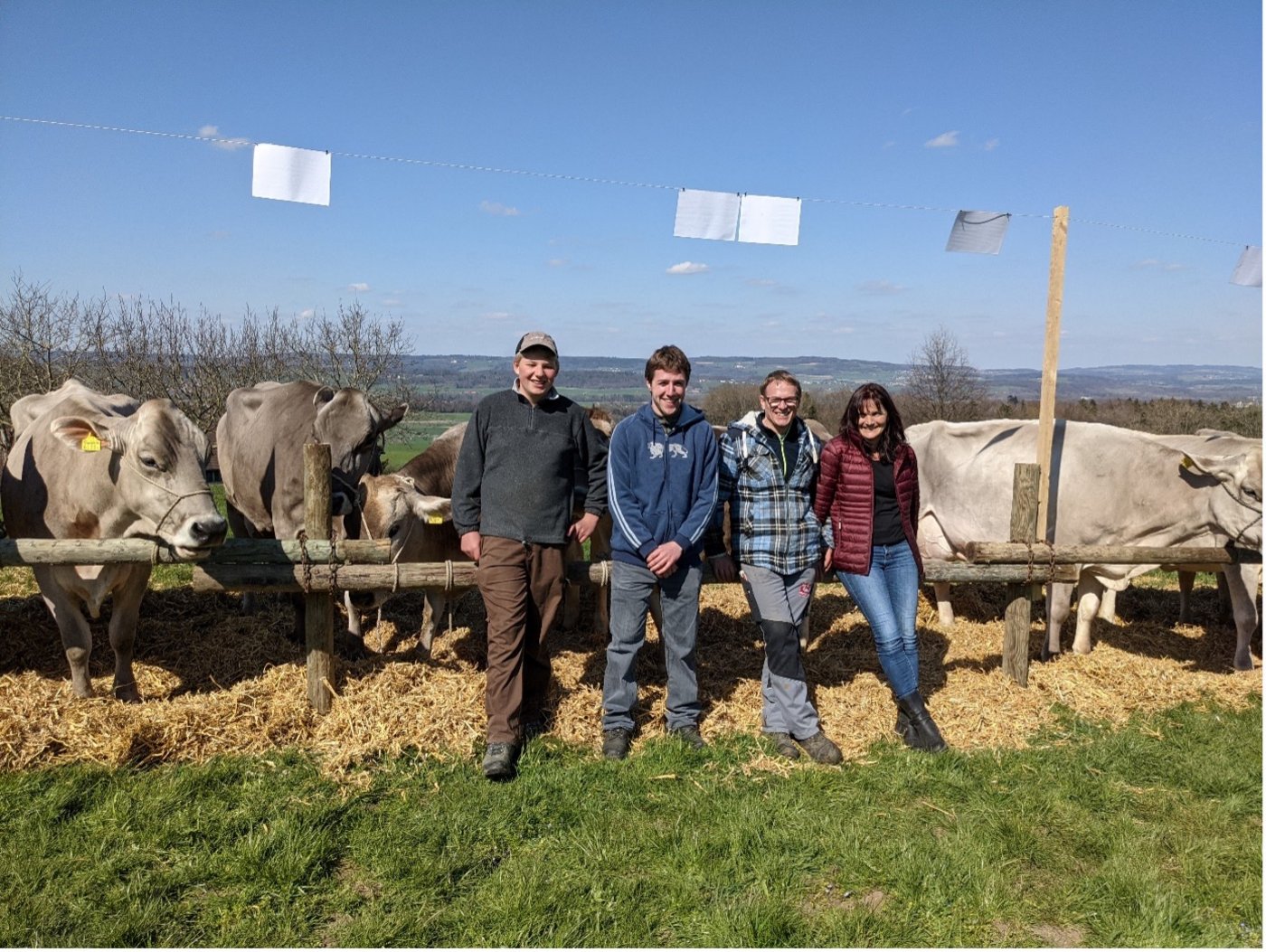 Roman Eugster mit Gabriel Frei und dem Betriebsleiterpaar (v. l. n. r.). Im Hintergrund die Zuchtfamilie. (Bild zVg)