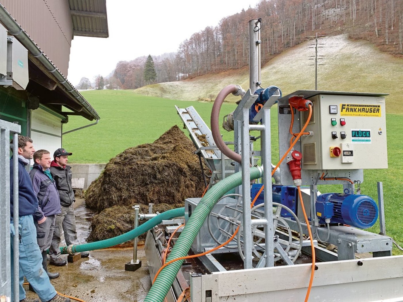 Hans Flück, Flück Landmaschinen Kerns OW, Landwirt André Windlin und Konstrukteur Martin Krummenacher (v. l.) begutachten den Betrieb des mobilen Gülle-Separators im Melchtal OW.(Bild Josef Scherer)