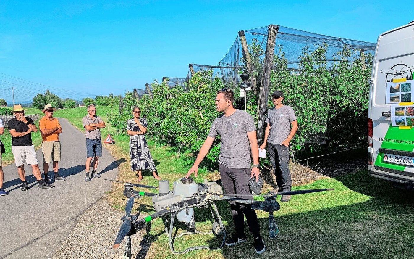 Philipp Schmidli und Martin Niederberger (r.) von den Agrarpiloten Zentralschweiz präsentieren den Weinbauern auf dem Betrieb vom Südhang in Eschenbach den Einsatz der Drohne für den Pflanzenschutz im Rebbau.
