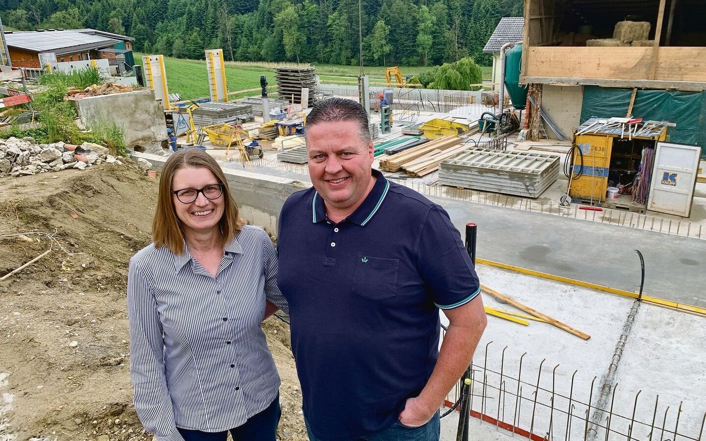 Natalie und André Frank auf der Baustelle für die neue Scheune. Hinten in der Mitte das neue Wohnhaus, links die Schweinescheune.