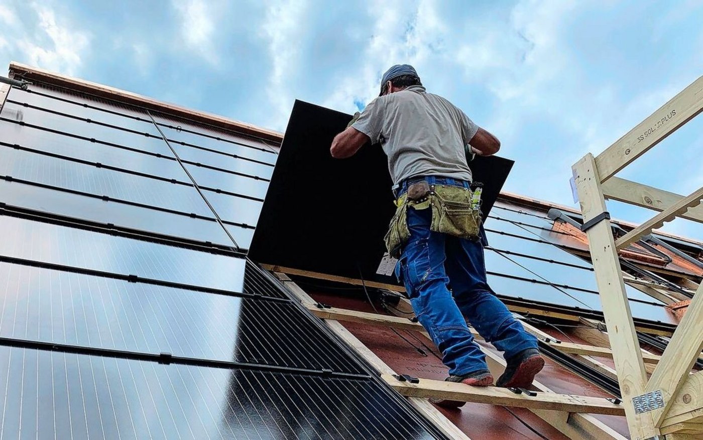 Montage von PV-Modulen für eine Indachanlage auf einem Neubau. Solche Systeme sind zwar teurer als Aufdachanlagen, dafür können die Ziegel eingespart werden.