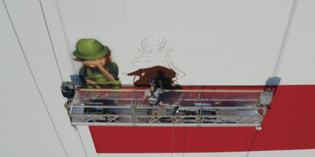 Mural Artist Ralph Hospenthal bei der Arbeit in grosser Höhe. Das Wandbild soll auf die Gegenargument zu den Initiativen aufmerksam machen. (Bild VSF)