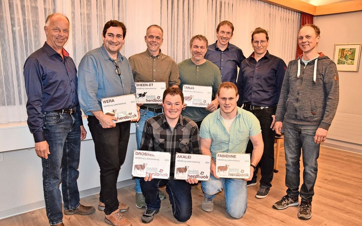 Die stolzen Besitzer der 100 000er-Kühe (mit Plaketten), umrahmt von Adrian Weber, Christian Burkhalter, Nicolas Berger und Adrian Aebersold (von links)