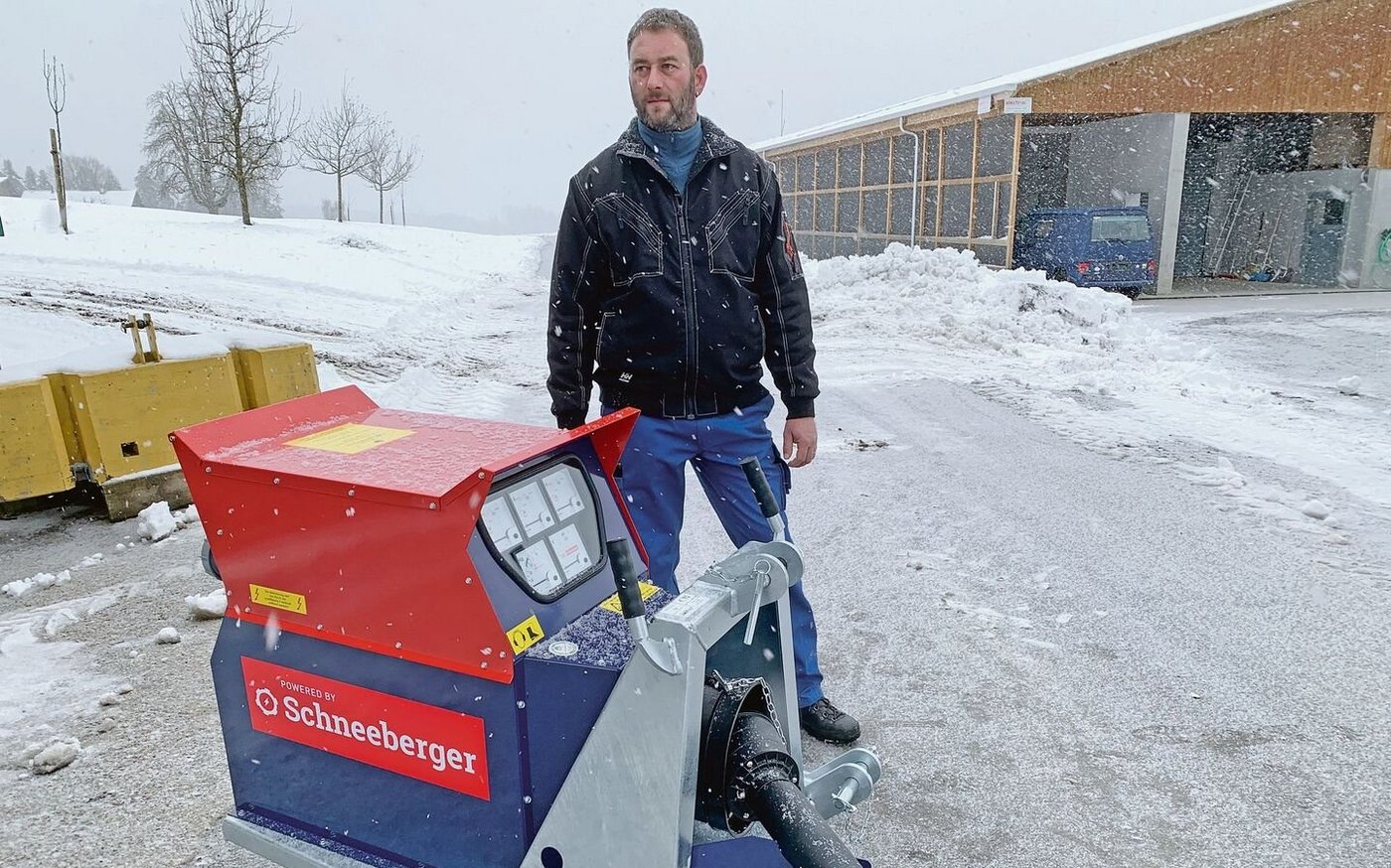 Passend zum Schneegestöber: Landwirt Beat Weltert vom Leidenberg, Grosswangen LU, mit dem neuen Schneeberger-Notstromaggregat. Im Hintergrund die Pouletmasthalle. 