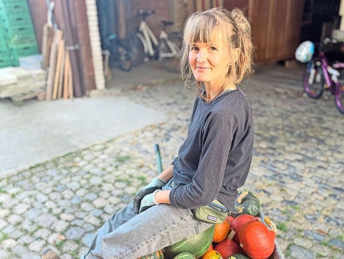 Ernteglück: Sarah Elser auf einer Karette voller Kürbisse.