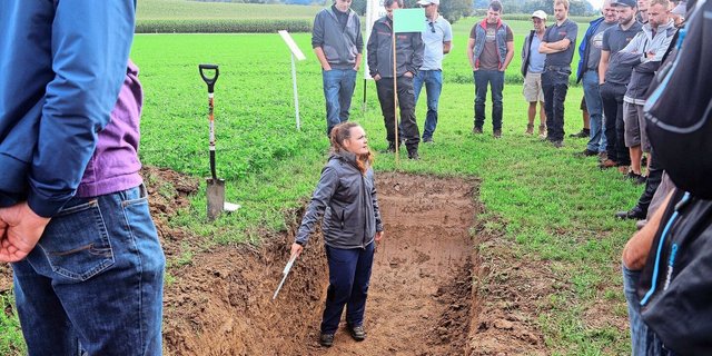 Anhand eines ausgehobenen Profils erklärt Rita Ziltener den Kursteilnehmern die Beurteilungskriterien für die Bodenqualität.