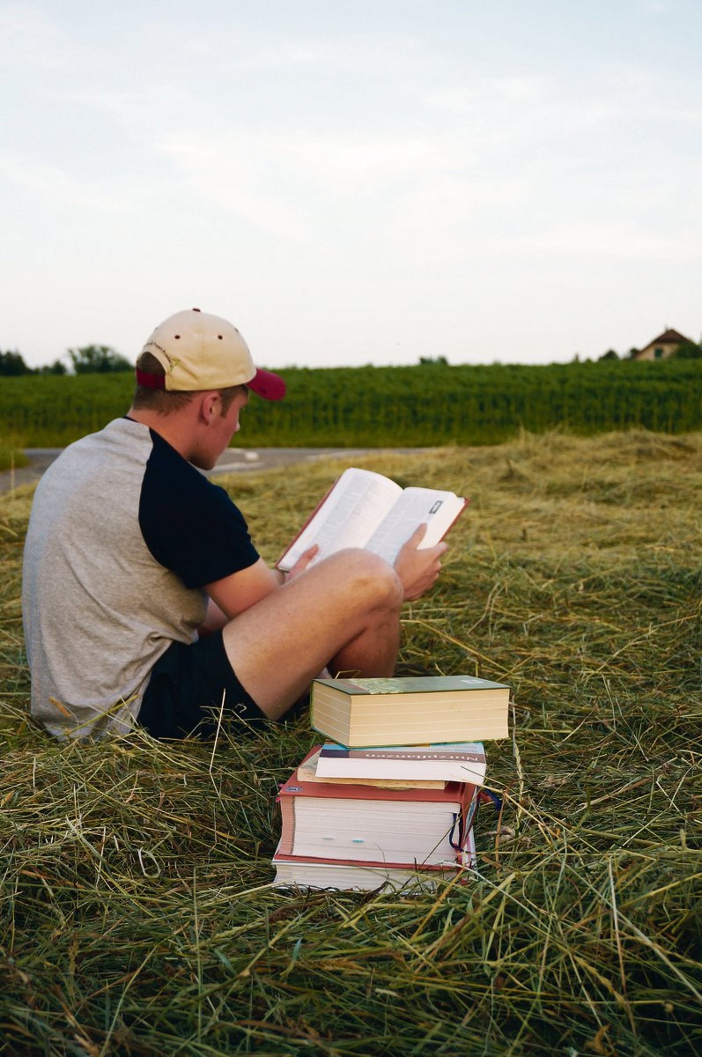 Der Bücherstapel auf dem Acker sieht etwas befremdlich aus. Das täuscht: Praxis und Theorie beissen sich nicht, sie ergänzen sich wunderbar.(Bild Deborah Rentsch)