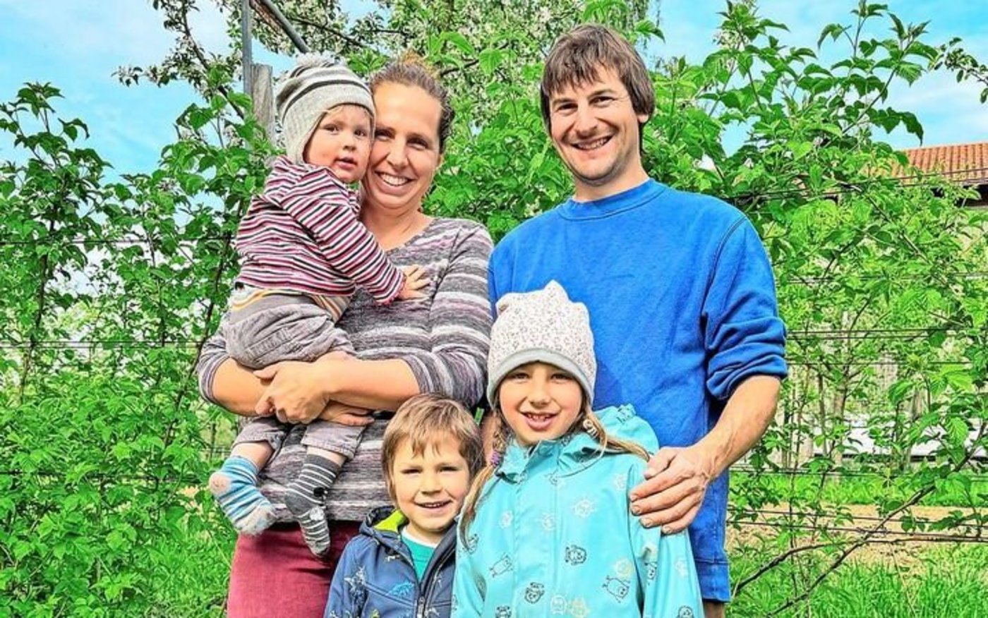 Martina und Stefan König mit ihren Kindern Nora, Lionel und Julian vor ihrer Hecke aus Beeren.  