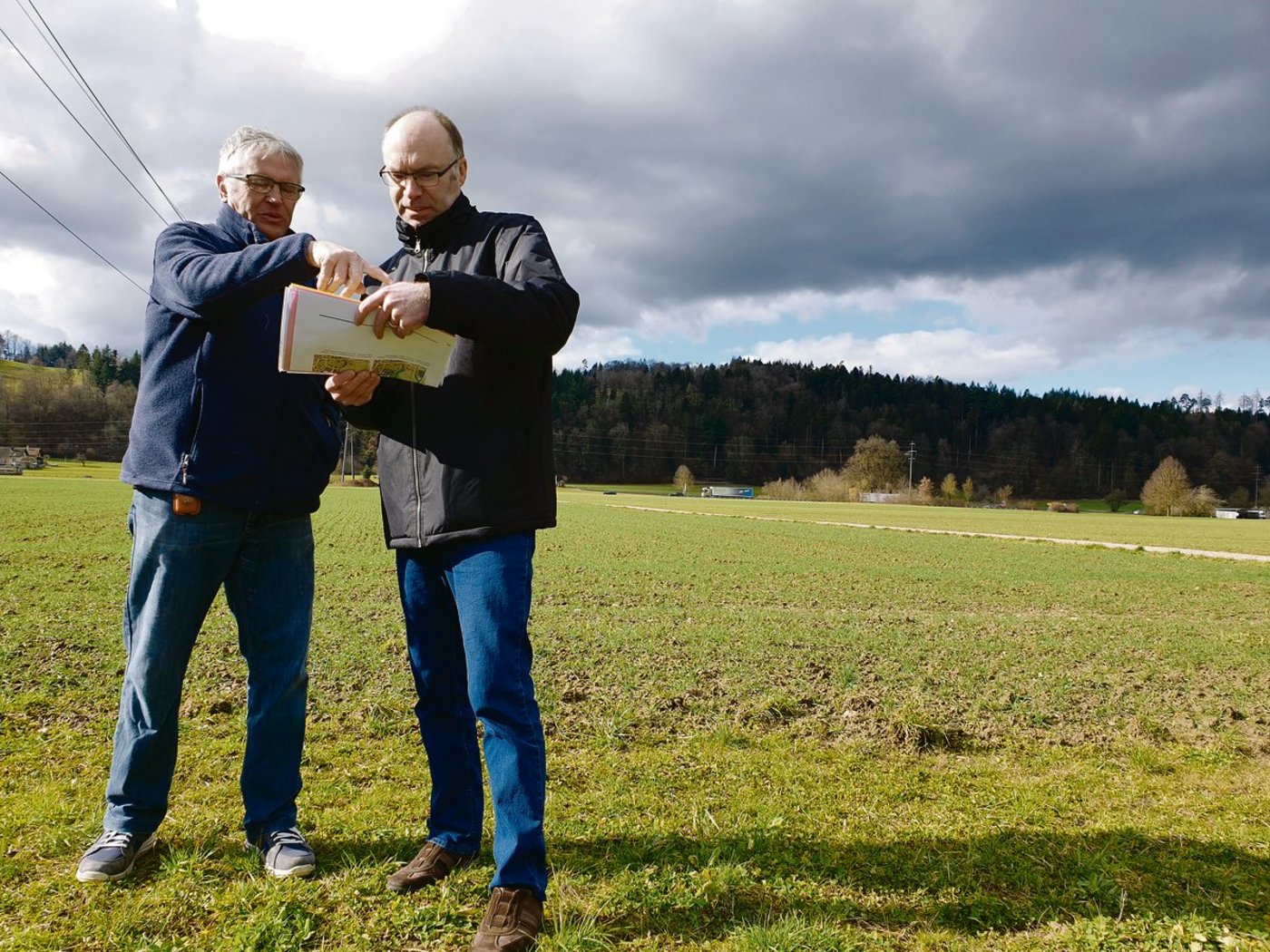 Sie wollen die zehn Hektaren grosse «Hegmatte» als Landwirtschaftsland erhalten: Hans Lüthy (l.), dem ein Drittel der Fläche gehört, und Andres Wälty vor dem umstrittenen Gebiet.  (Bild Ruth Aerni)