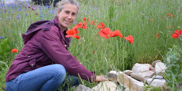 Bioloca Präsidentin Nora Winzeler  ordnet einen Steinhaufen im Kräuterbeet. (Bild Marianne Stamm)