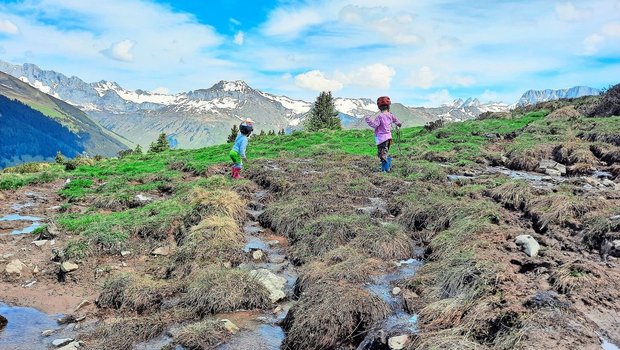 Zahlreiche Schmelzwasserbäche fliessen noch über die Weiden, sie sind das reinste Kinderparadies. Für Ronya und Cyrill gibt es viel zu entdecken.