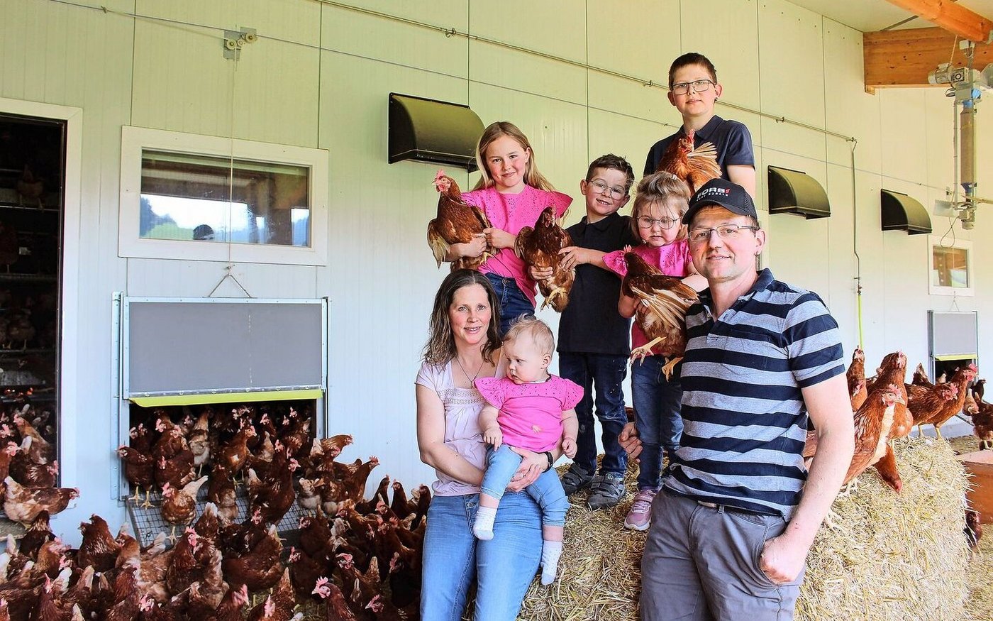 Patrizia und Christian Bamert-Weishaupt mit ihren Kindern Jonas, Angelika, Reto, Lilian und Andreina, umgeben von ihren Legehennen. Neben Hühnern halten sie auch Rinder und Milchkühe. 