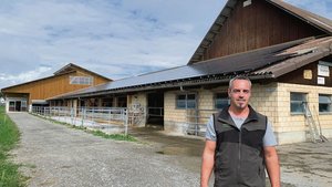 Stefan Troxler vor der 2013 erstellten Solaranlage auf dem Scheunendach. Diese wurde 2021 auf eine Leistung von 130 kWp erweitert. Der meiste Solarstrom muss ins Netz abgegeben werden.  