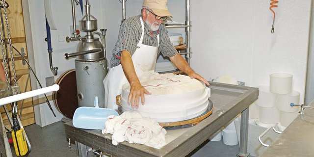 Käsermeister Bernard Schneuwly hat den Käsebruch soeben in die Form gepasst. Alle Beteiligen sind glücklich darüber, wie der erste Alpsommer in der neuen Käserei gelaufen ist. (Bild Josef Jungo)