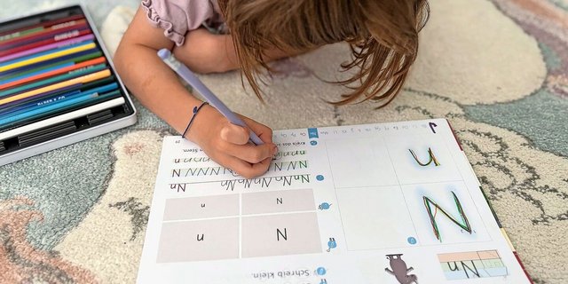 Auf dem Teppich statt am Tisch: Martina Brühlmann plädiert dazu, das Kind den Ort für die Hausaufgaben selbst wählen zu lassen. Wenn es lieber liegt oder steht, warum nicht? Sitzen muss es in der Schule schon viel. 