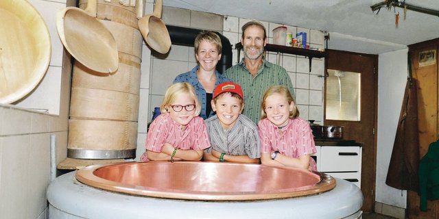 Myrtha und Siegfried Fischli mit den Kinder Nina,  Marc und Sara (v. l. n. r.) hinter dem Kessi, in dem sie den Alpziger herstellen.(Bilder Barbara Schirmer)