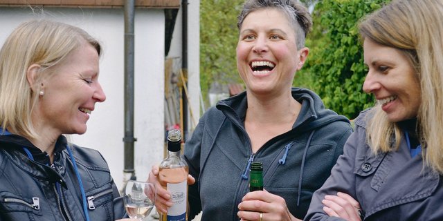 Christine Alder (Mitte) schenkt ihren Gästen vom LSV Uetendorf hofeigenen Wein aus.(Bild Franziska Schawalder)