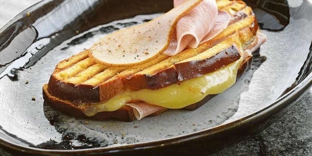 Dieser Croque trägt ganz die Handschrift des Kantons Freiburg. Die Cuchaule, das Freiburger Safranbrot, ist mit Vacherin Fribourgeois und Bénichonsenf gefüllt.   