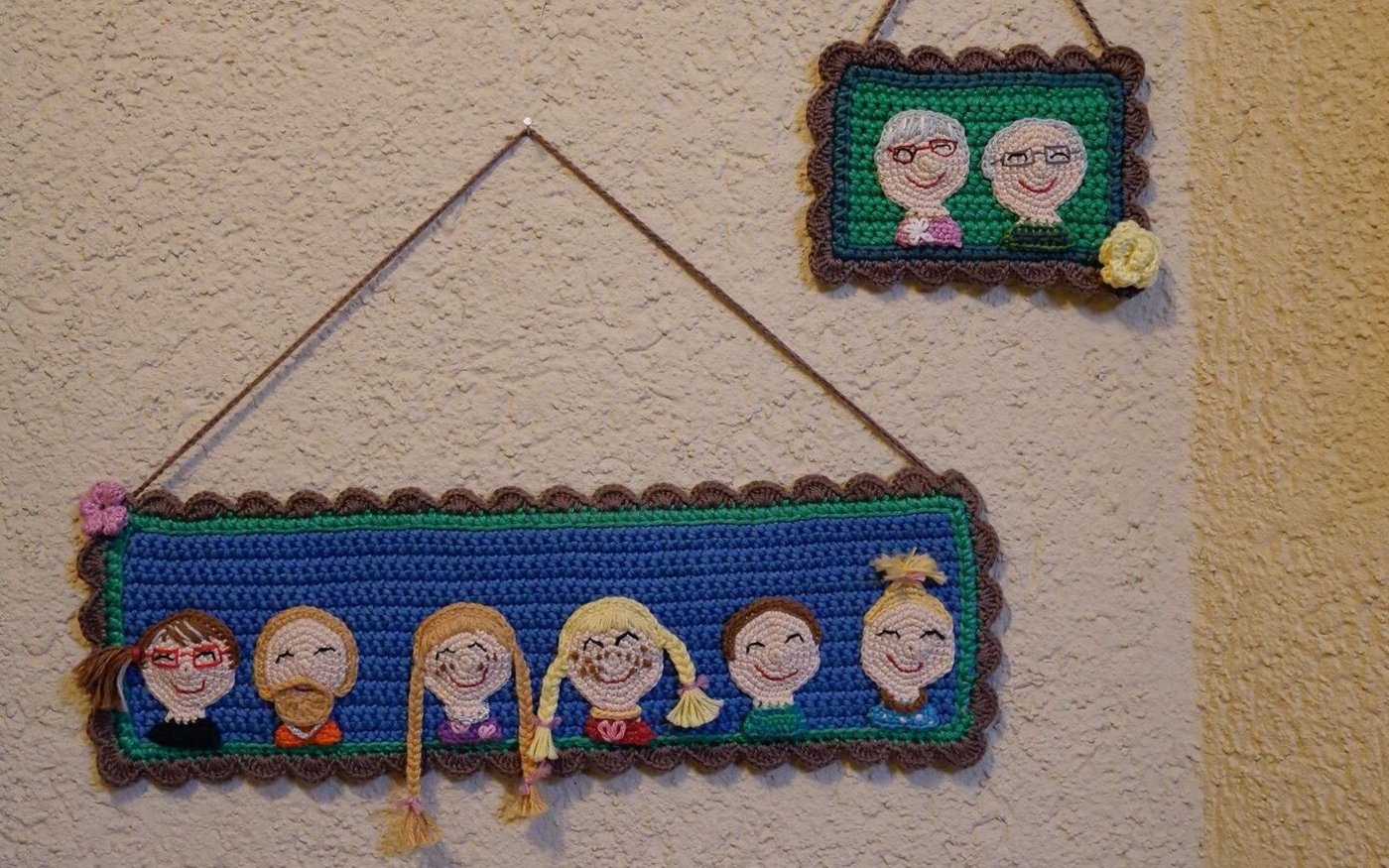 Im Korridor des Hauses hängt ein selbst gehäkeltes Schild, das alle Bewohner des Hauses zeigt.