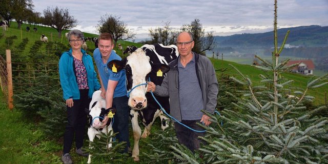 Betriebsleiterpaar Marlies und Peter Hodel mit Sohn Adrian präsentieren Stammkuh HoWi Fever Rosina mit Kalb.