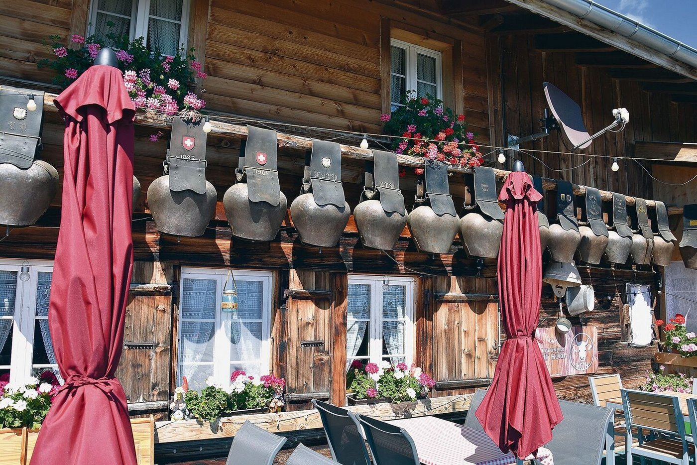 Die Alphütte ist geschmückt mit Zügeltreicheln. Von der Terrasse aus sieht man ein gewaltiges Alpenpanorama.