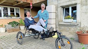 Anita Binker mit ihrem Sohn Adrian Reusser, der stolz sein Spezial-Liegevelo vorführt, das ihm ein Stück Selbstständigkeit gibt.