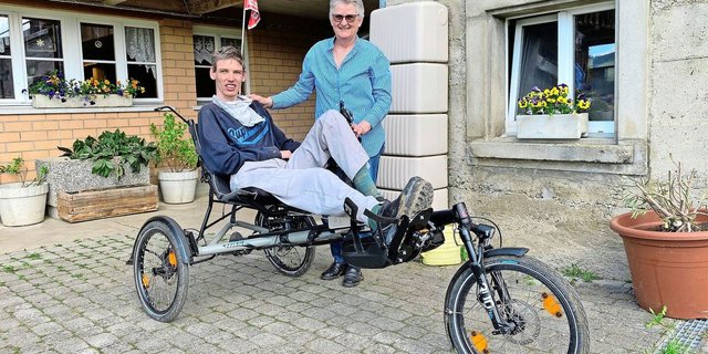 Anita Binker mit ihrem Sohn Adrian Reusser, der stolz sein Spezial-Liegevelo vorführt, das ihm ein Stück Selbstständigkeit gibt.