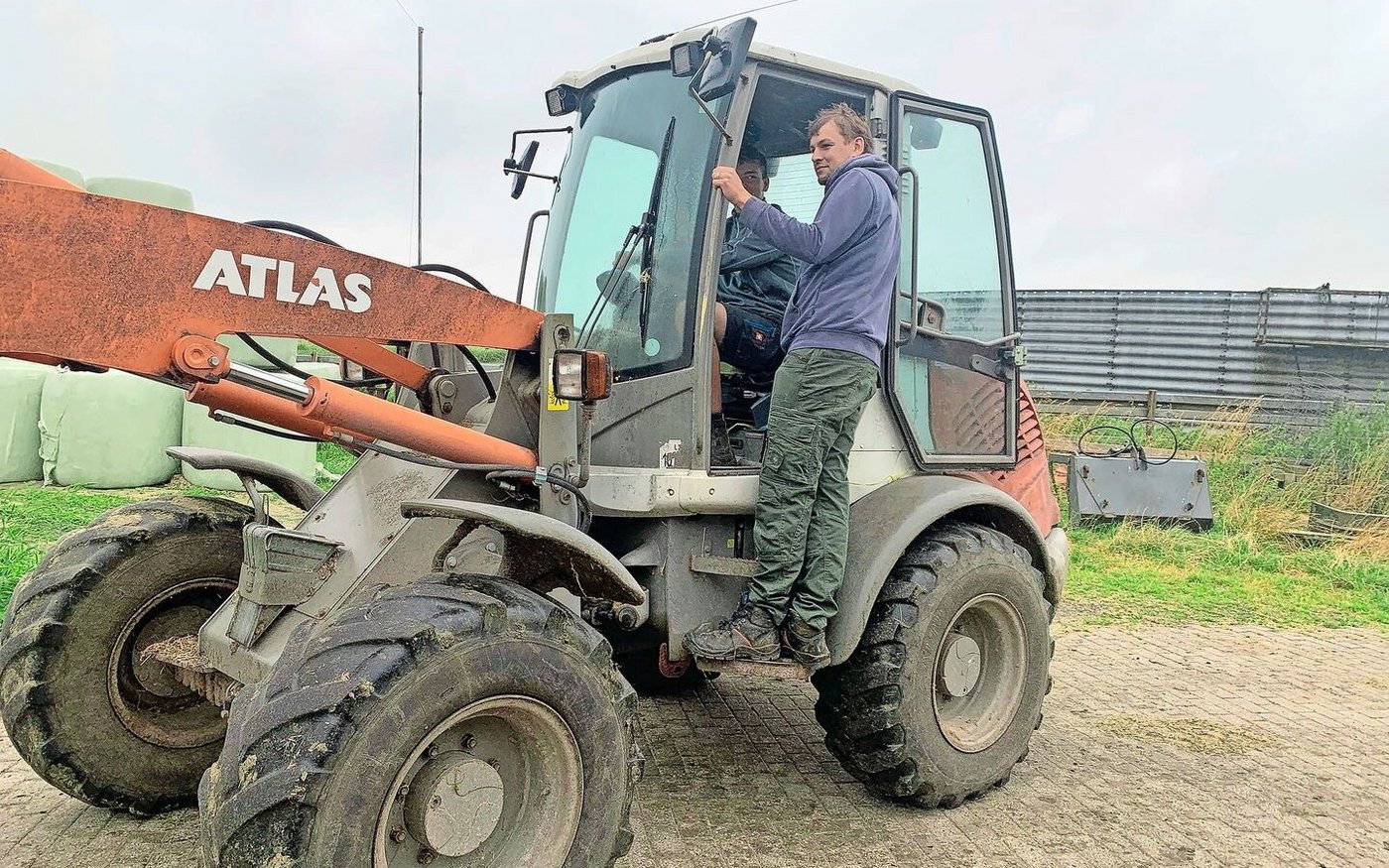 Jannik ist schon ziemlich geübt im Umgang mit den Maschinen. Lehrmeister Timo gibt ihm kurz eine Instruktion beim Siloballenfahren. 