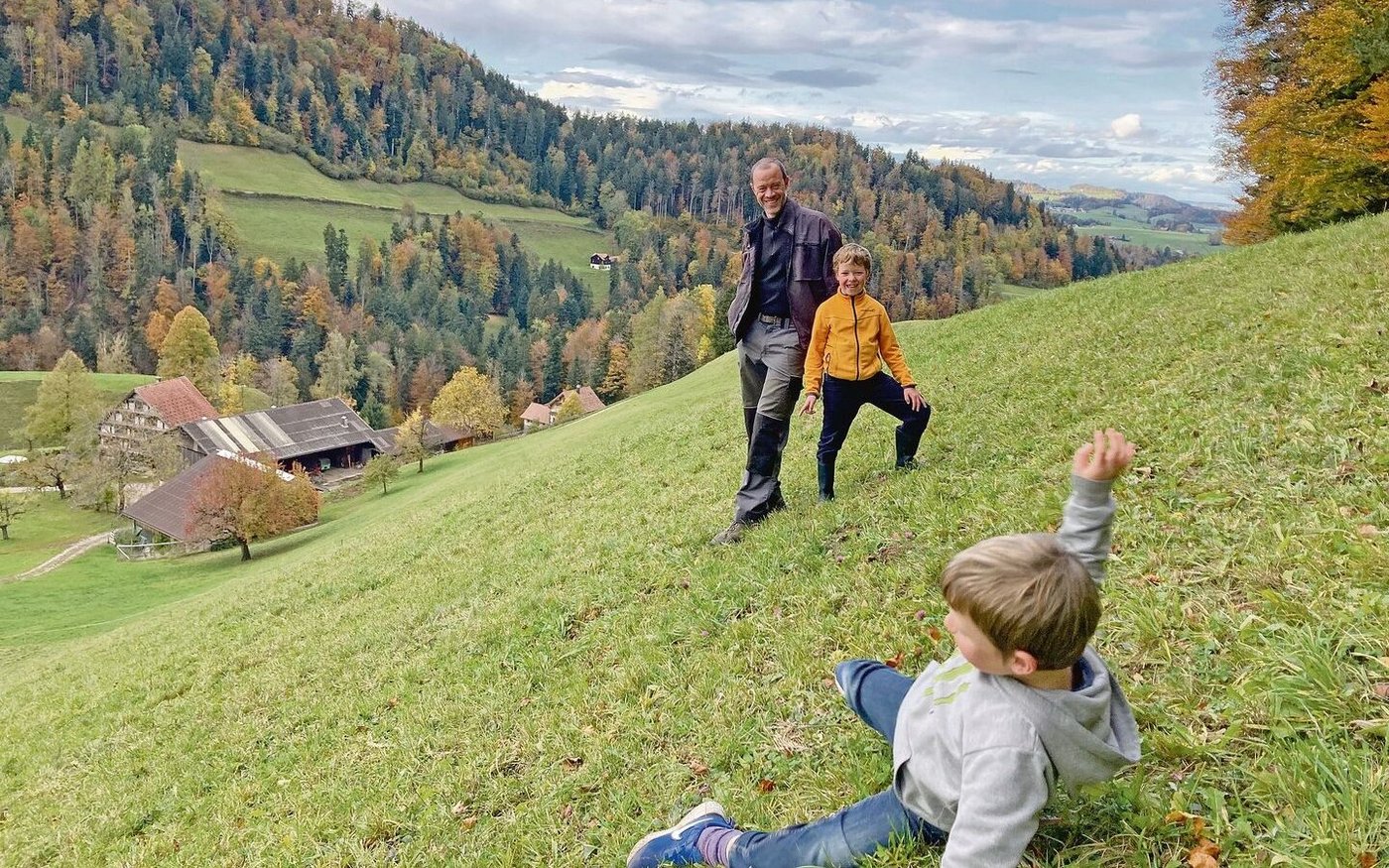 «Schau, wie steil es ist», sagt Josias und demonstriert das mit Purzelbäumen am Hang. Hinten: Jakob Wickli mit Sohn Aaron (Frau Lucienne, Tocher Annalena und Sohn Linard fehlen).