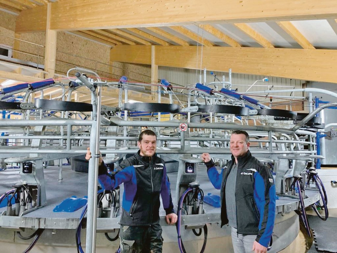 Bertrand Godel (r.) und sein Bruder Pascal vor ihrem neuen Melkkarussell, das seit Mitte November 2020 läuft. (Bild zVg)