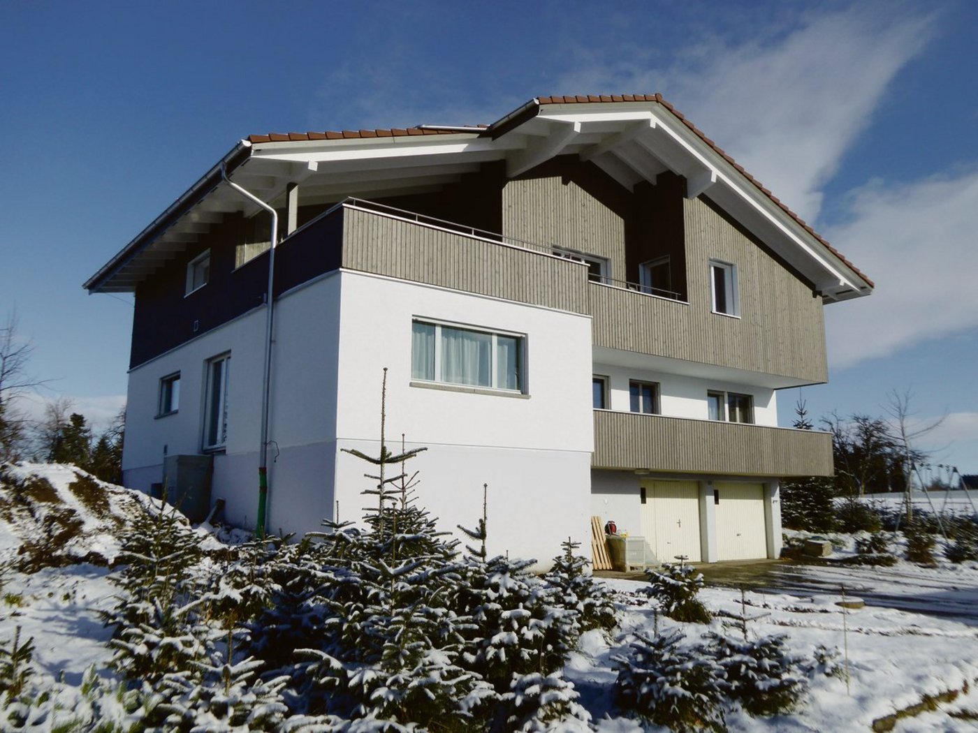 Der Ersatzneubau für ein Wohnhaus mit zwei Wohnungen. Viel Holz, aber nicht nur. Unterbau und gemauertes Treppenhaus (l.) wurden übernommen. (Bild Hubert Meier)